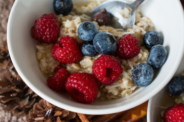 Oatmeal with berries in a bowl. Rasberries and blueberries. Flax seeds