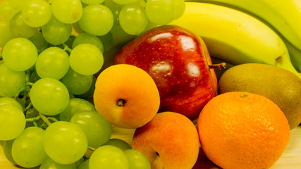 Obstschale-Weintrauben, Bananen, Äpfel, Aprikosen und Orangen bestandteil einer gesunden Ernährung
