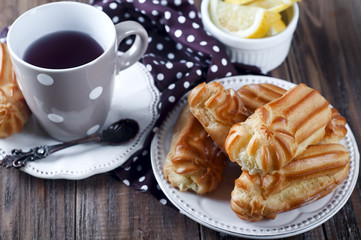 Tasty eclairs on wooden table