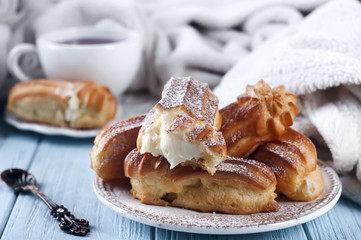 Tasty eclairs on wooden table