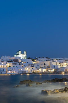 Blue hour of Naoussa village at Paros island in Greece showing the beautiful local church.
