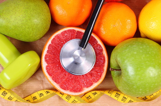Fresh fruits, centimeter, stethoscope and dumbbells for fitness, healthy lifestyles