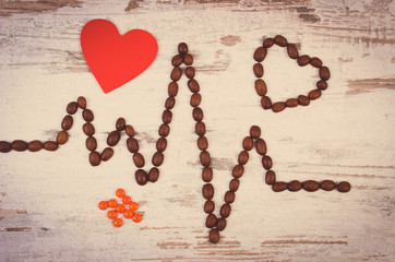 Cardiogram line of coffee grains, red heart and supplement pills, medicine and healthcare concept
