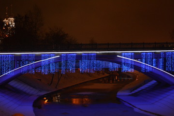 Beautiful bridge with lights over the frozen river in winter, city view, scenery
