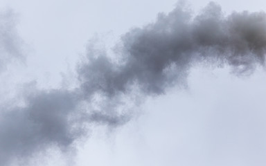 Fototapeta na wymiar Smoke from a pipe on a cloudy sky