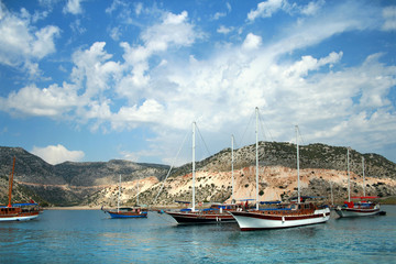 Fototapeta na wymiar Яхты на фоне острова и облачного неба в Турции