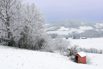 cabanon rouge dans un paysage enneigé
