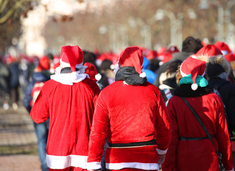 people with red Santa Claus clothes run during the sporting even