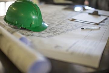 Construction helmet on blueprints in site office