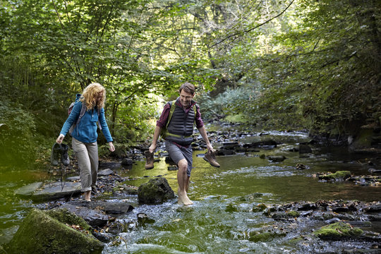 Couple hiking crossing a river