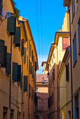 Fototapeta na wymiar Clear blue sky peeking through onto a Bologna alley. 