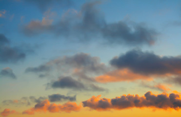 Cumulus sunset clouds with sun setting down