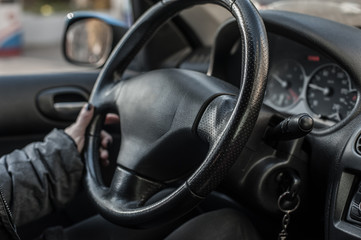 Obraz na płótnie Canvas Closeup of woman hand on the steering wheel