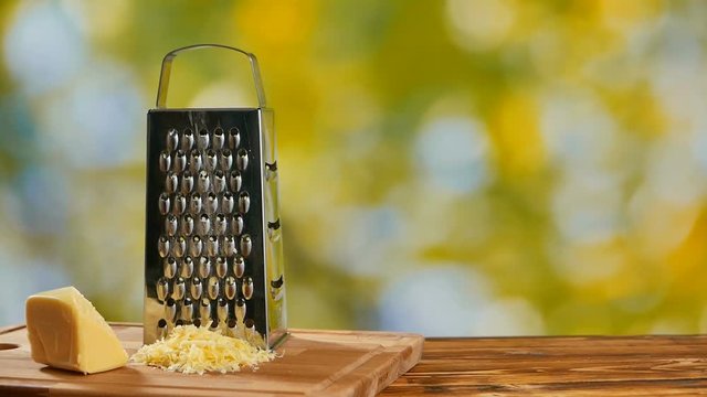 Grater and parmesan cheese on the wooden table