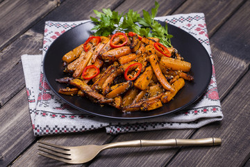 Roasted carrots in black plate, close up