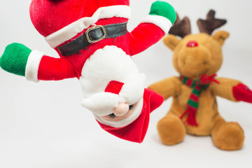 Closeup Santa doll and reindeer doll out of focus on white backg