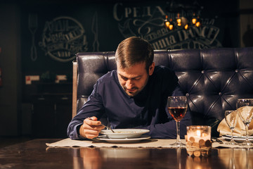 the man eats the soup at the restaurant