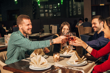 Two happy smiling young couples with champagne at celebration