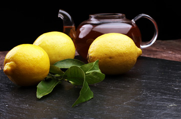 Cups of tea, lemon and mint on table on wooden background