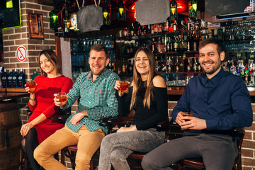 company of two couples resting at the bar and drinks