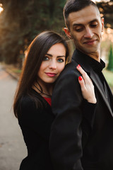 Young couple holding hands, smile and walk in the park in one au