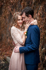 Portrait of happy newlyweds in autumn nature. Happy bride and gr