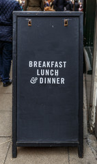 Advertisement for breakfast, lunch and dinner, on a black backgr