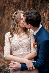 Portrait of happy newlyweds in autumn nature. Happy bride and gr