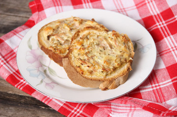 Baked bread slices with button mushroom, yellow cheese and ham dressing