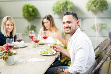 Young man eating out with his friends