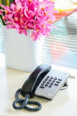Black landline telephone on counter desk in the hotel.