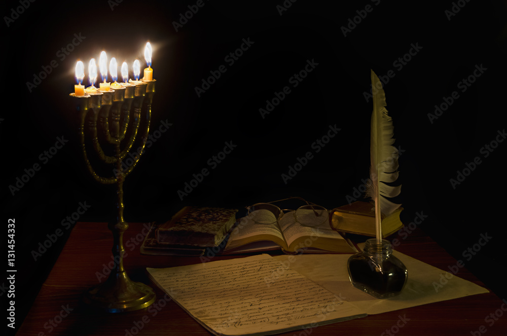 Fototapete old writing desk iluminated by menorah. text in the notebook is in old bulgarian ecclesiastical lang