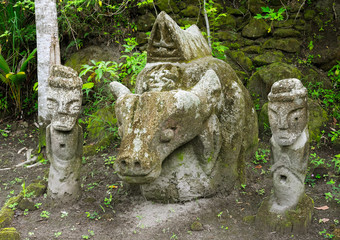 Sculpture of buffalo representing coffinette kistn and two men keepers by the both sides, carved from the stone. Near Ambarita Stone Chairs monument at Lake Toba, North Sumatra, Indonesia.