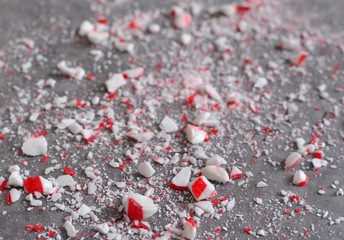 Crushed peppermint candy cane bits sprinkled on wax paper background