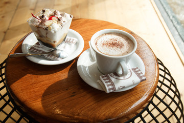 A cup of hot coffee latte and a delicious sweet dessert.