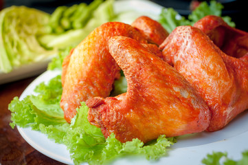 Grilled chicken wings with vegetables on dish