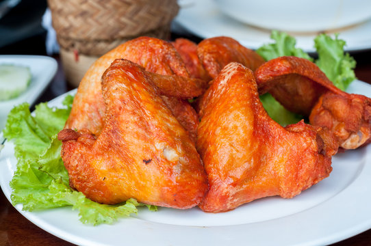 Grilled chicken wingd on plate and vegetables