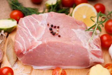 Raw pork on cutting board and vegetables 
