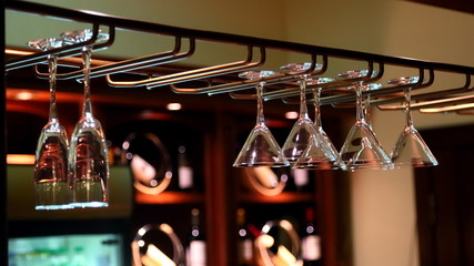 Fototapeta na wymiar Empty clean wine glasses are hanging above the bar
