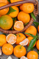 Fresh tangerines with leaves in a wooden basket