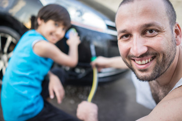 Young father and little sons washing ca