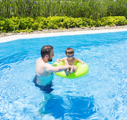 Dad teaching kid to swim