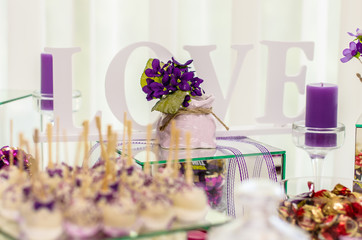 the word love on the background of sweets and flowers