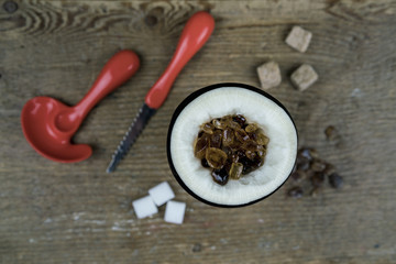 Brown and white sugar lumps and kitchen utensils on table with halved turnip filled with candy