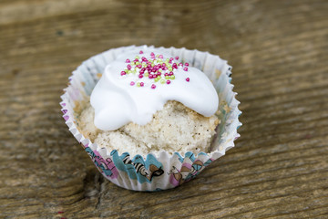 Closeup of homemade cupcake with iced topping on wooden table