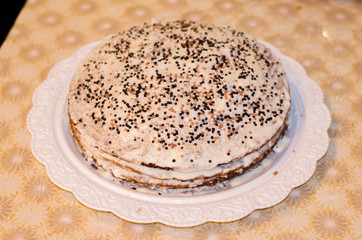 медовый торт со сметанным кремом на белом блюде