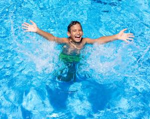 Happy children on summer vacation swimming pool having fun and h