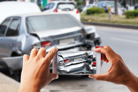 Close up hand holding smartphone take photo of car accident
