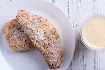 Almond croissants on dish next to smoothie