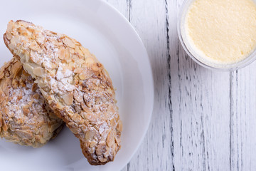 Almond croissants on dish next to smoothie